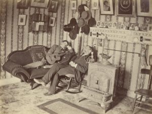 Trinity College Old Campus, Brownell Hall (1845-ca.1877), Interior: Brownell Hall Suite No. 28 with William G. Mather '77 on rocking chair, and Joseph Buffington '75 on sofa. 1875, Photographer unknown.