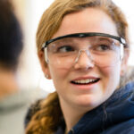 An inspired Trinity college student wearing safety goggles