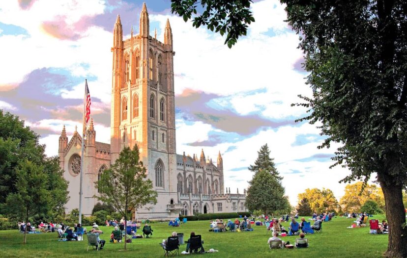 The Trinity College Chapel with students sitting on the grass