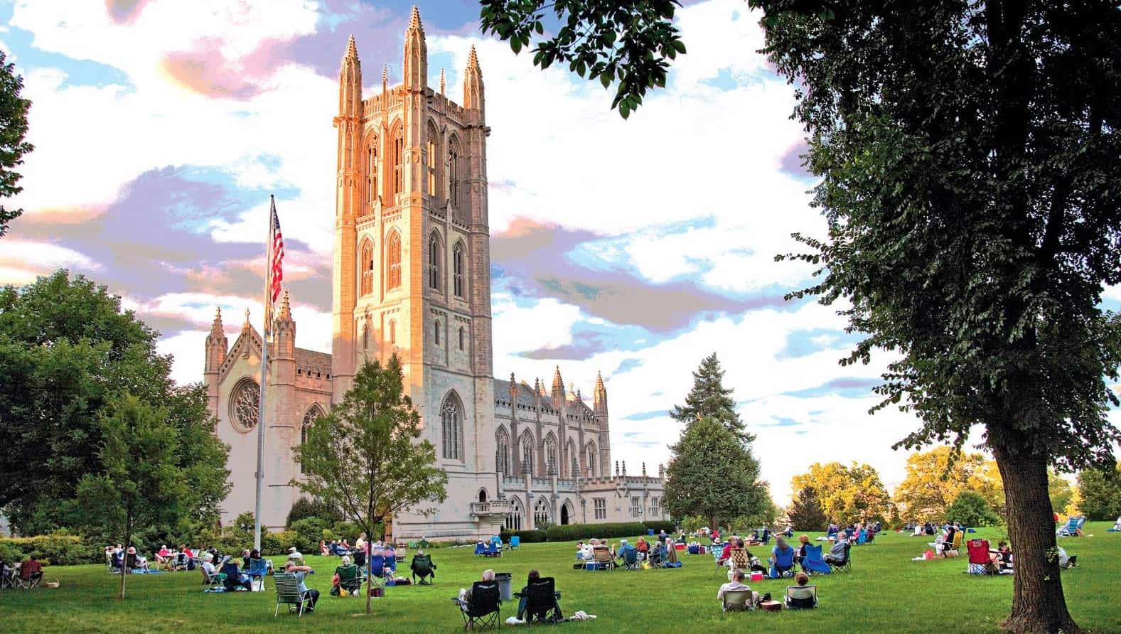 The Trinity College Chapel with students sitting on the grass