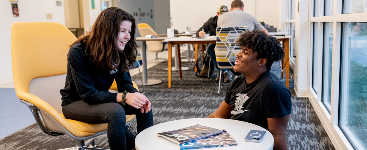 Two trinity college students conversing in a study lounge