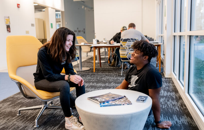 Two trinity college students conversing in a study lounge