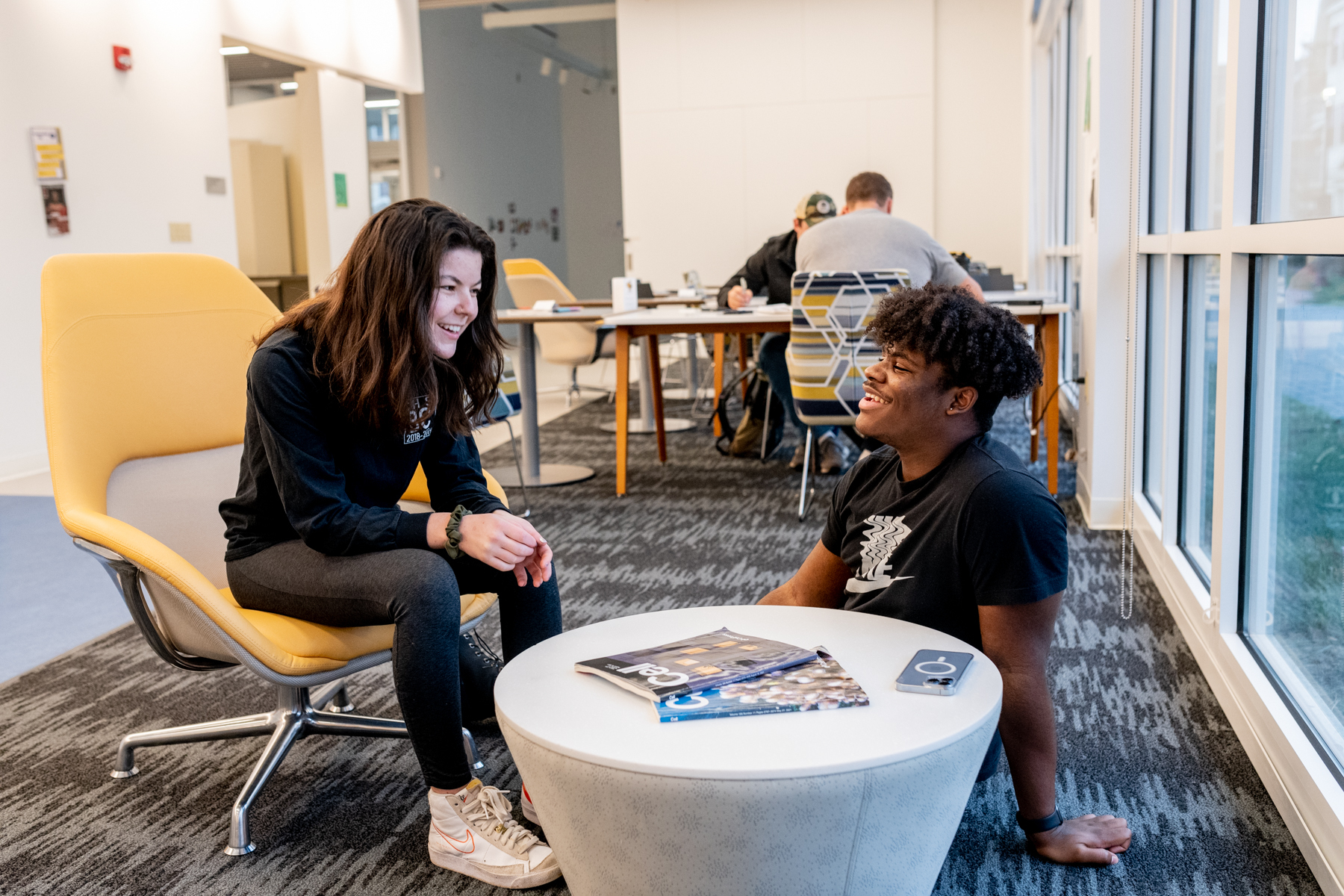 Two trinity college students conversing in a study lounge