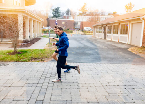 Trinity college student athletes running through campus