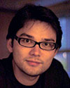 Photo of Reo Matsuzaki with short dark hair and dark rimmed glasses