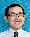 Photo of Brian Chin smiling with dark rimmed glasses