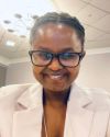 Photo of Florence Muhoza wearing white jacket and dark rimmed glasses