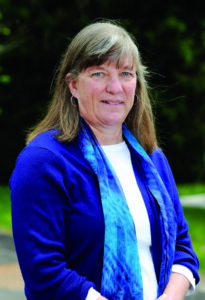 Ann McNichol posing in a bright blue blazer and blue scarf