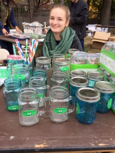 a student with mason jars and reusable straws