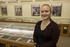 Abigail Waldron M'20 stands near the "Pulp Art of Science Fiction’s Golden Age" exhibit she curated.