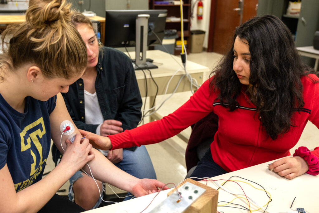 Scarlett Gillette ’23, Alisyn McNamara ’23, and Ananya Swamy ’23 apply sensors. 