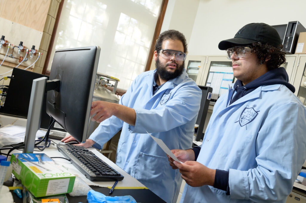 Jonathan T. Ashby ’09, assistant professor of chemistry, works in the lab with Ethan Andujar ’27. Photos by Nick Caito.
