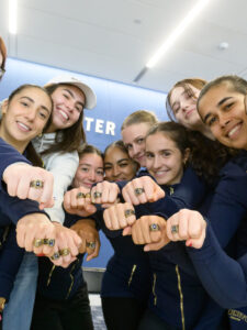 Women's squash players showing off their rings