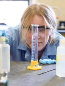 A student looks at a graduated cylinder
