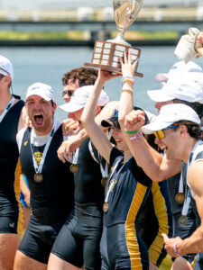 Men's rowing team pose excitedly with the national champtionship trophy