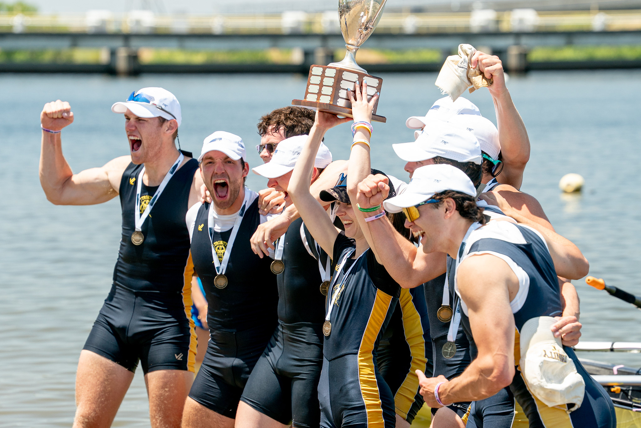 Men's rowing team pose excitedly with the national champtionship trophy