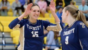 A liberal arts student-athlete high-fiving a teammate during a match